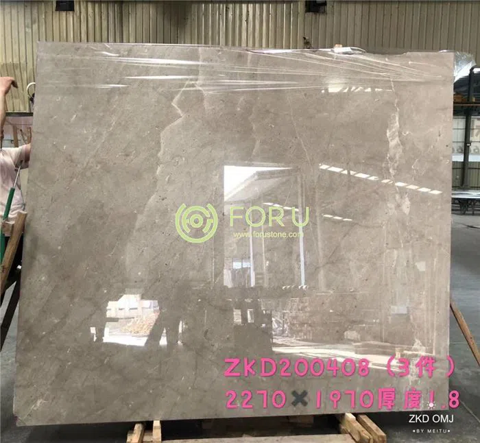 Multiple polished Castle Grey marble slabs displayed in a factory warehouse, highlighting continuous supply capabilities for large B2B commercial projects.