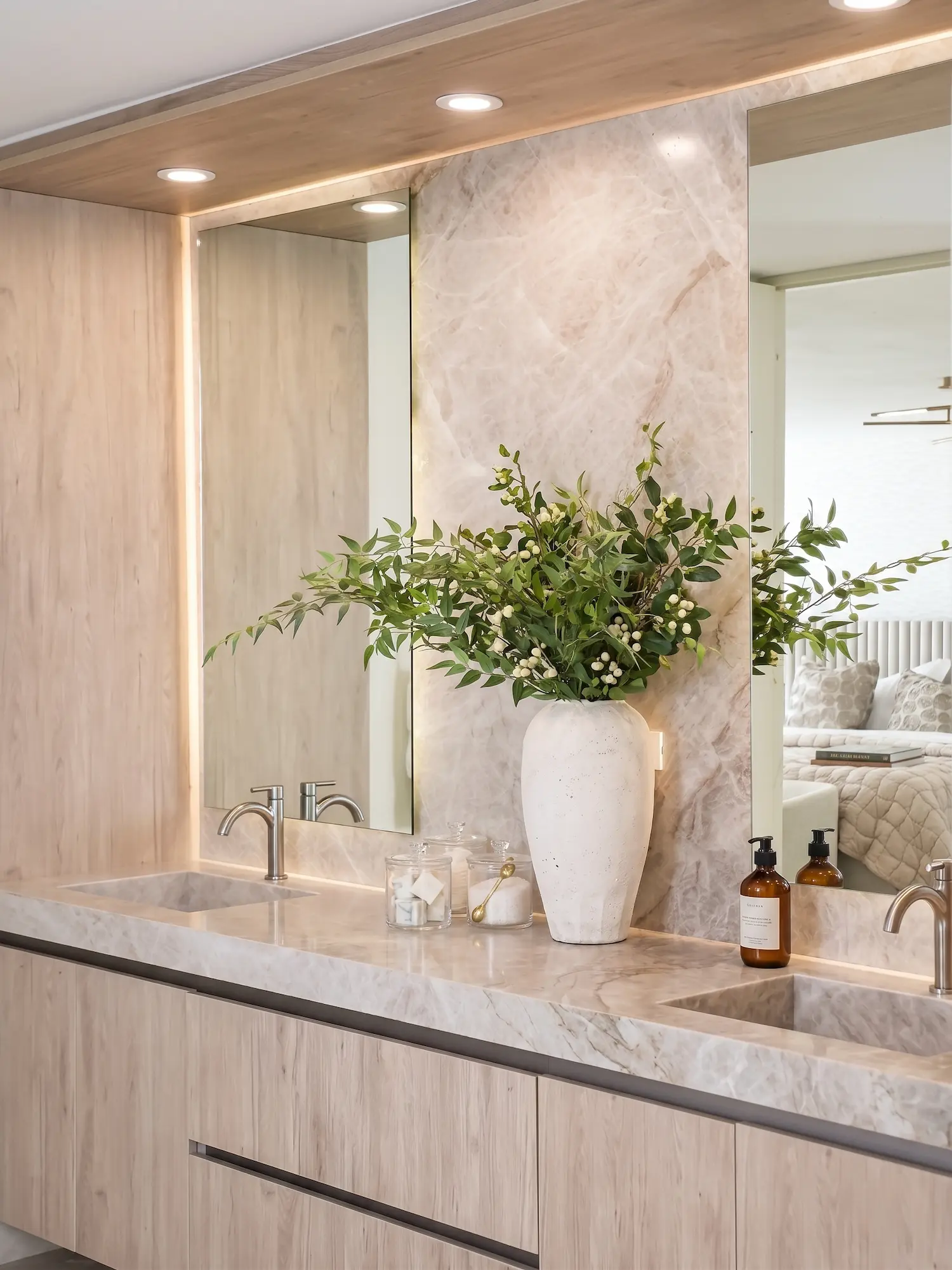 Taj Mahal Quartzite bathroom vanity countertop with soft beige veining and matching wall application in a warm luxury interior