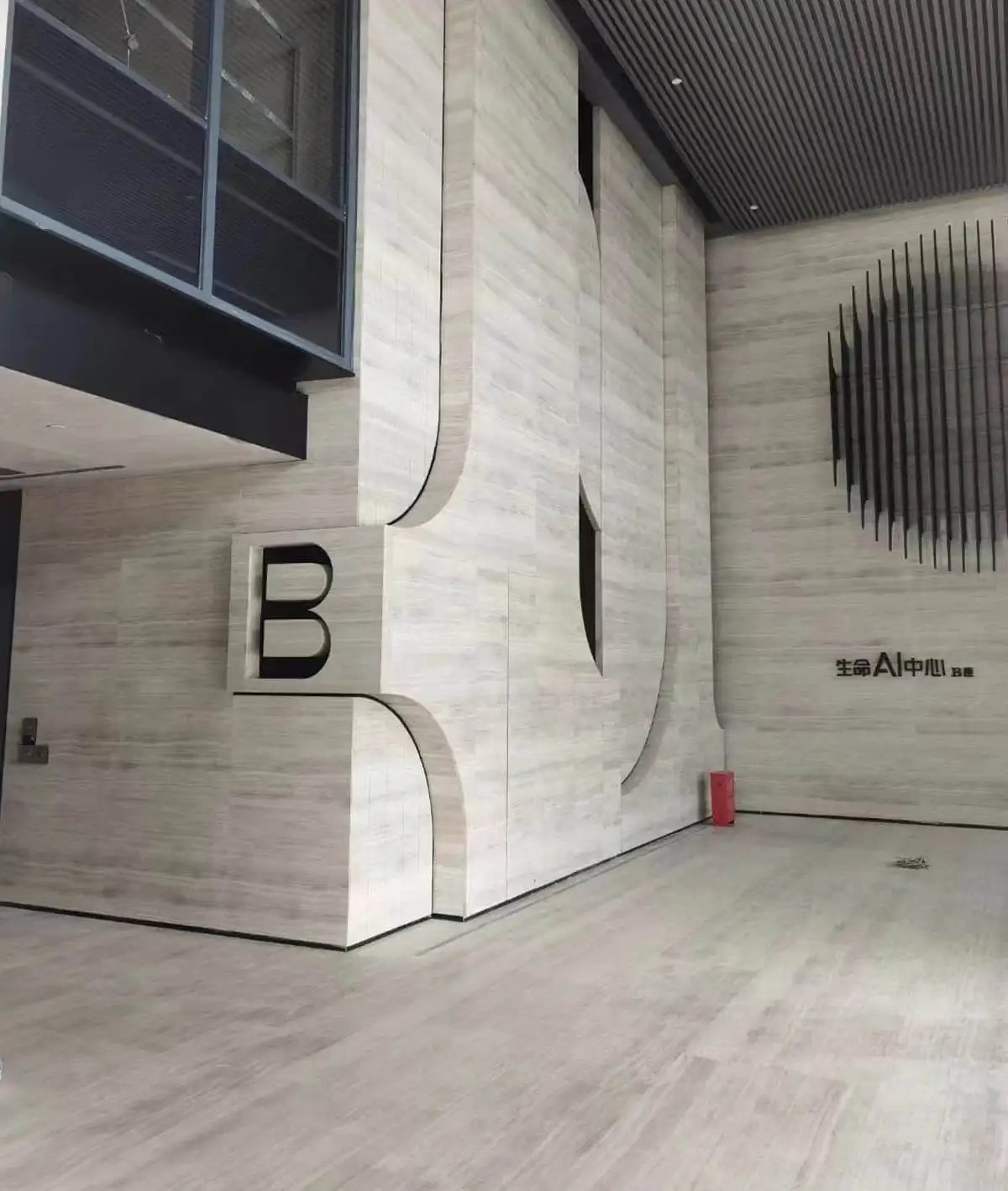 Silk Serpeggiante Marble Sculptural Curved Feature Wall with Letter B Signage for AI Industry Office Building Zone B LobbyFull wall and floor cladding of Silk Serpeggiante Marble in Zone B lobby of Life AI Center, featuring artistic curved hollow stone structure, 3D letter B marker and vertical metal linear wall installation.